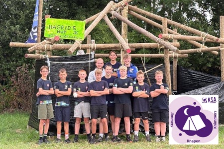 De knapen samen met hun leiding voor een zelfgebouwde constructie op kamp.